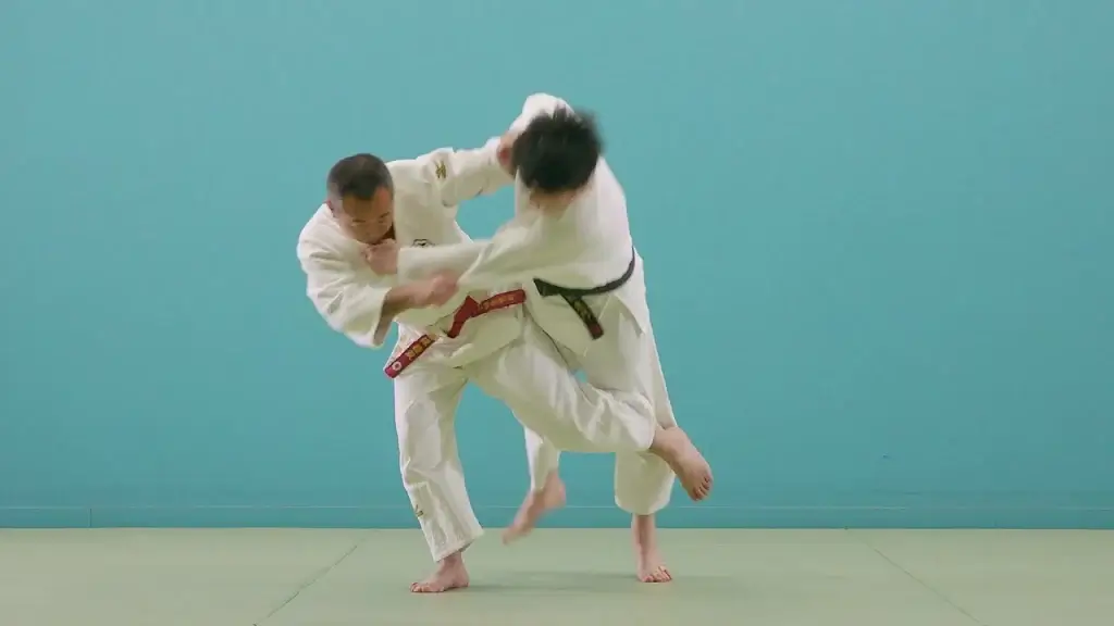 Judoka in der AusfĂŒhrung von Ashi-guruma.
