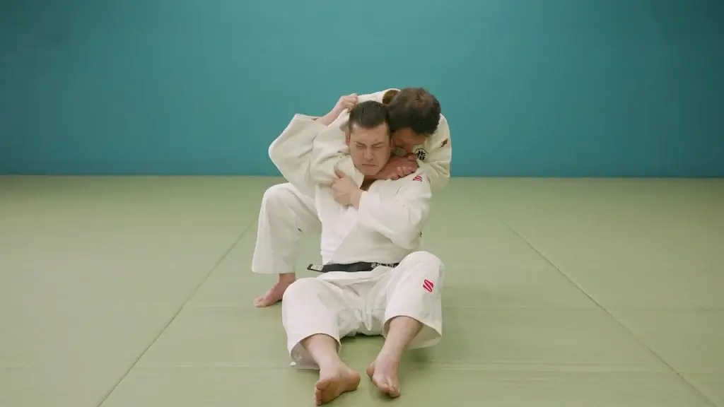 Judoka führt Hadaka-jime Würgetechnik aus.