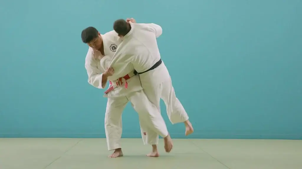 Judoka in der Mitte eines O-soto-gari Wurfs.