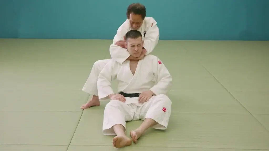 Judoka zeigt die Sode-guruma-jime Würgetechnik.