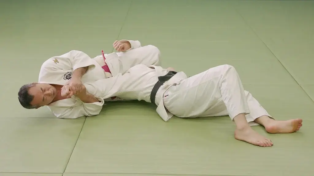 Judoka führt den Armhebel Ude-hishigi-sankaku-gatame aus.