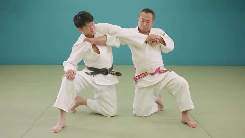 Judoka in Aktion mit Ude-hishigi-te-gatame.